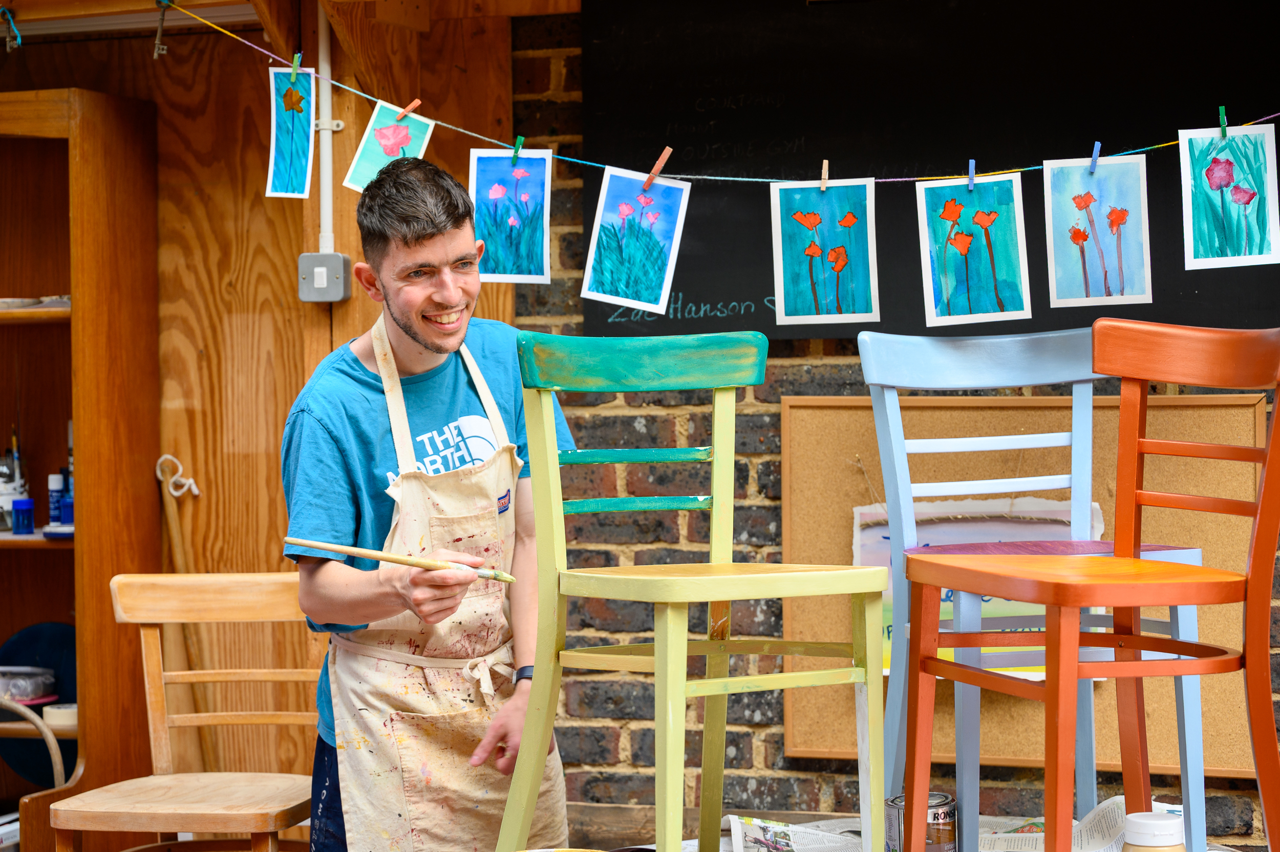 A young man painting an upcycled chair