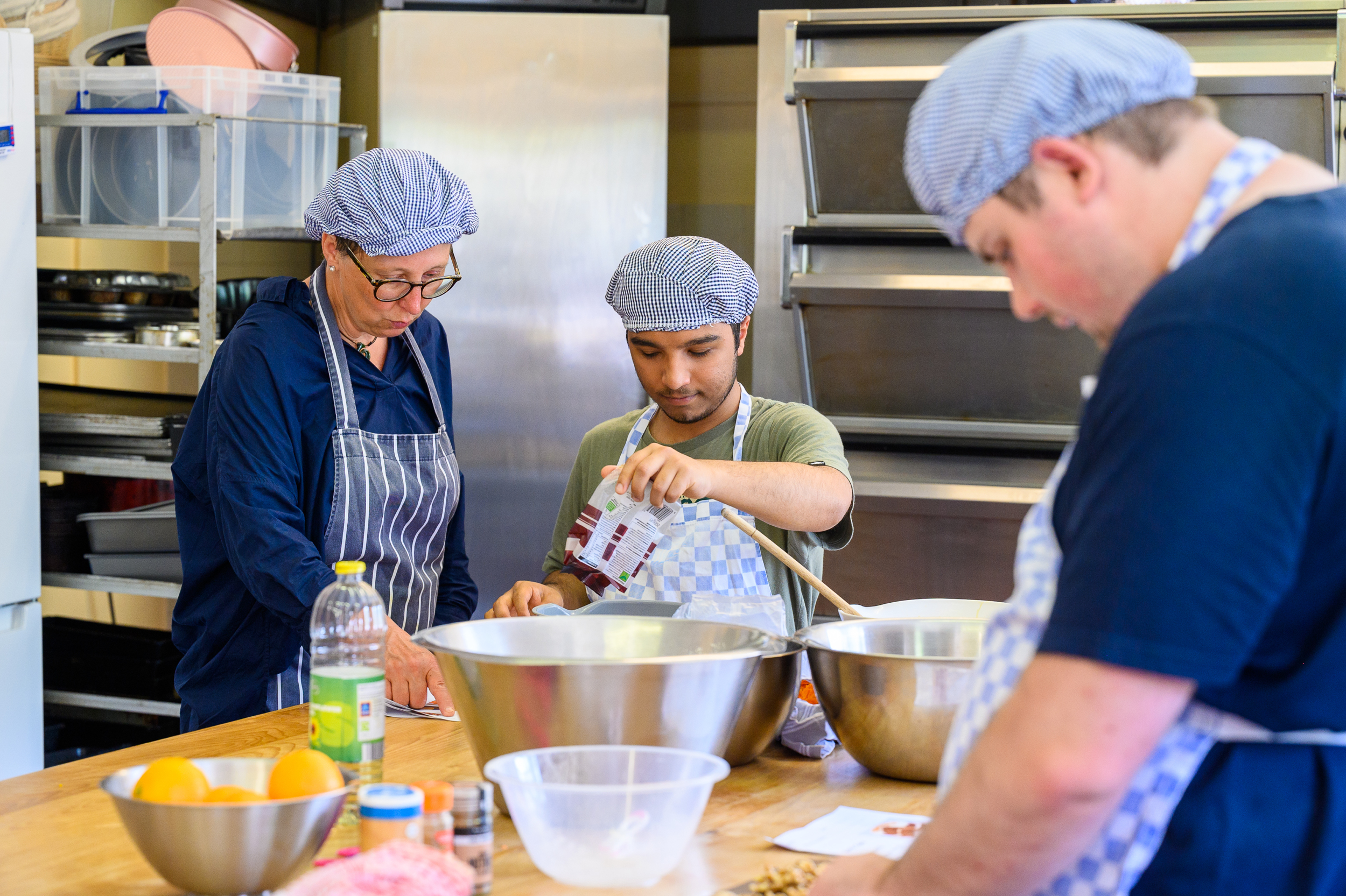 Two students mixing ingredients with the bakery tutor