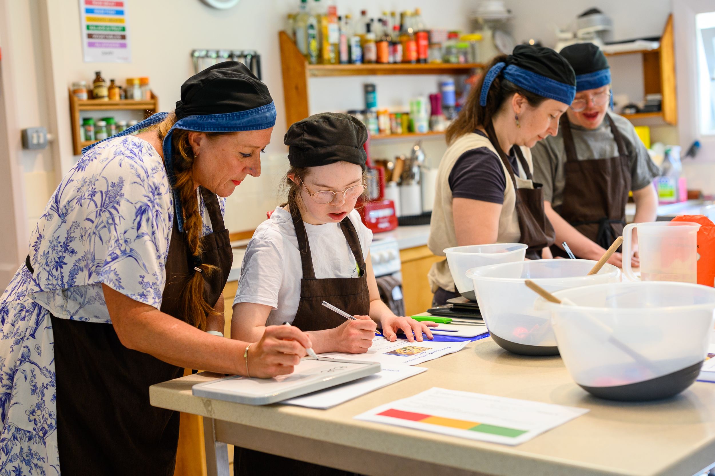 Students and tutors preparing a meal in our cookery classroom