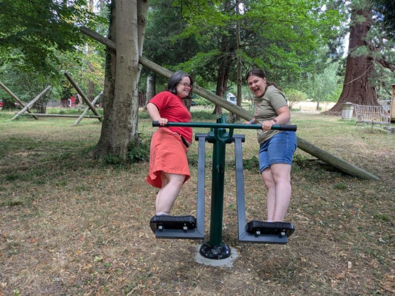 Two co-housers enjoying the outdoor exercise equipment