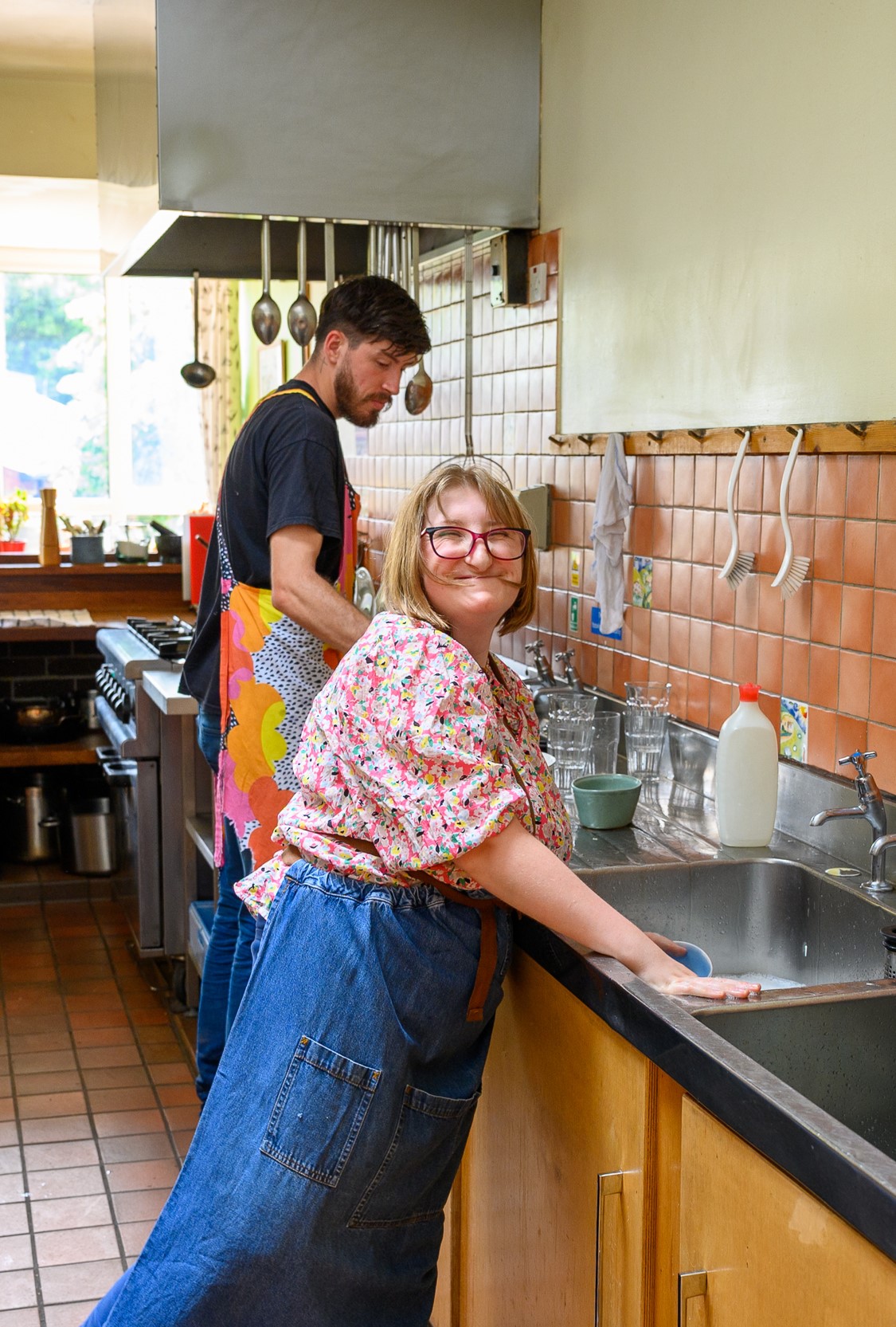 A student washing up with one of our co-workers.