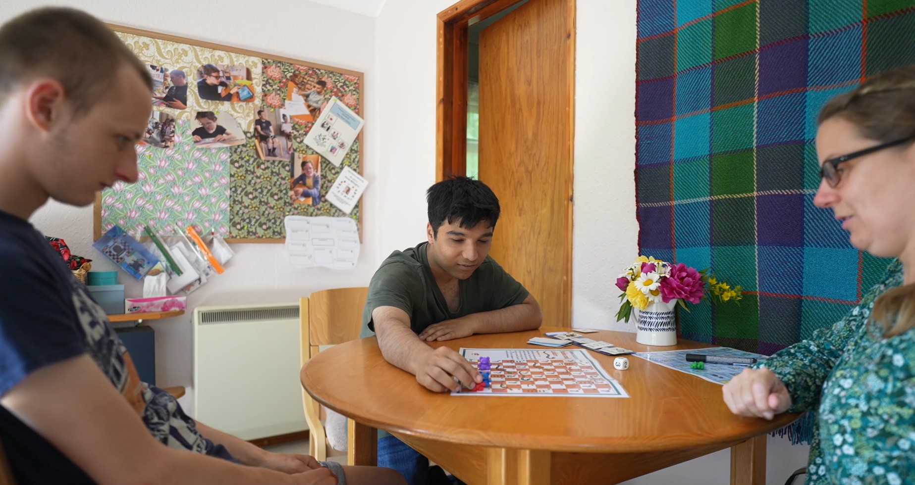 Two Students playing a board game with our Speech & Language Therapist.