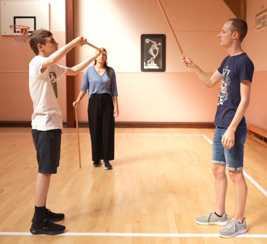 Two students taking part in rod fencing 